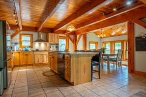 A spacious kitchen with wooden cabinets, a central island, and a dining area with a table and chairs.