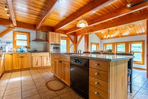 A kitchen with wooden cabinets, a dishwasher, and a large island.
