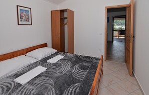 A bedroom with a bed, a wooden wardrobe, and a door leading to an outdoor area. - Beautiful home in Tkon with WiFi (Tkon)