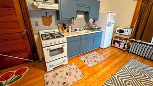Une cuisine de taille réduite équipée d’une cuisinière à gaz, d’un four et d’un réfrigérateur.