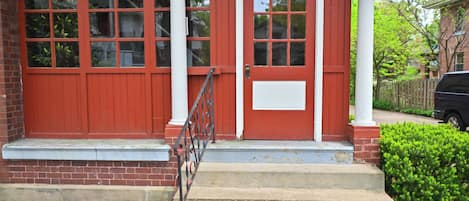 Un bâtiment rouge avec une porte blanche et de nombreuses fenêtres.