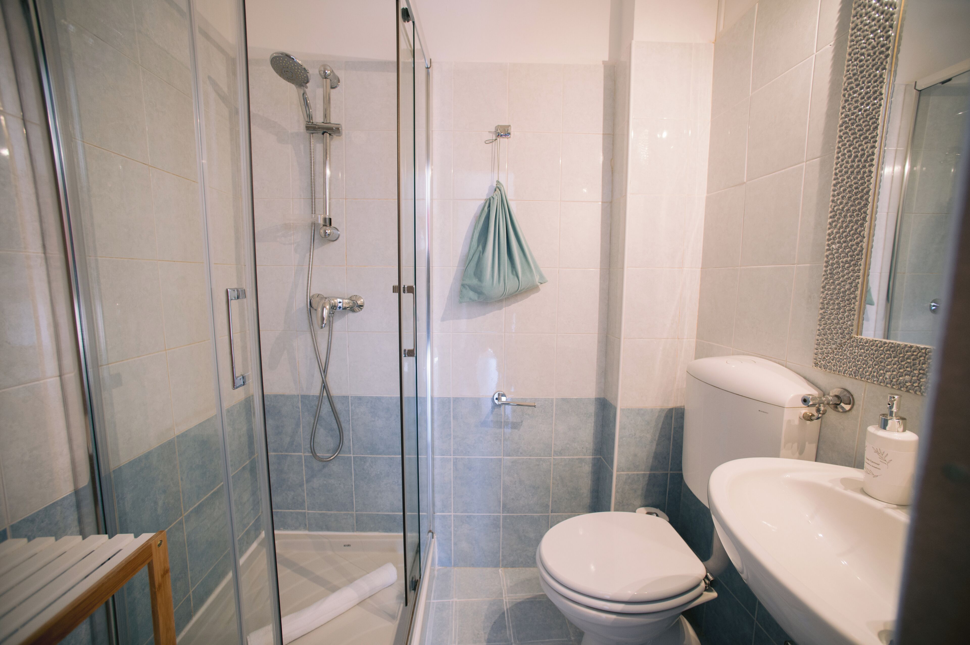 Un baño con ducha de vidrio, inodoro y lavamanos.