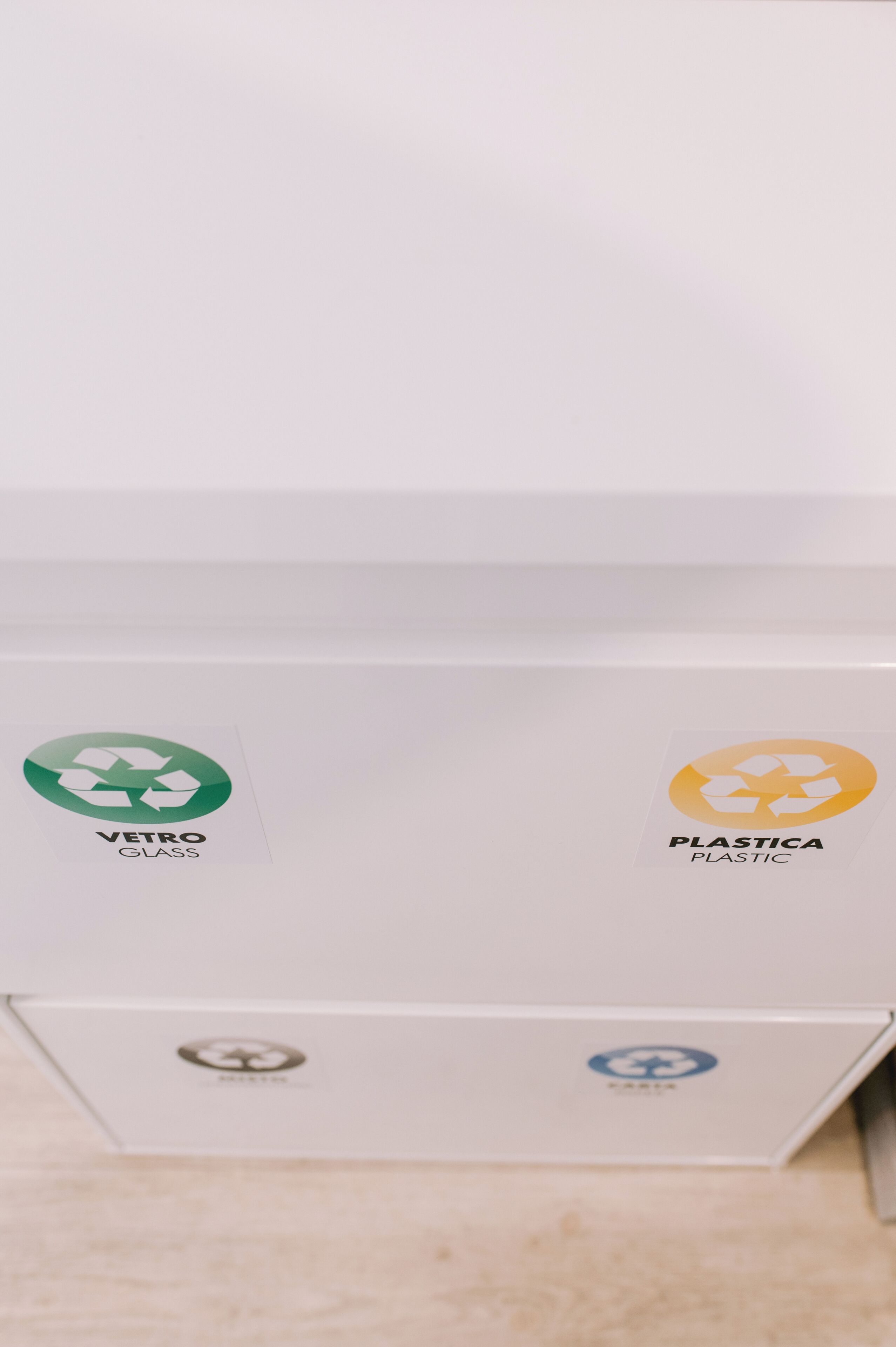 Een recyclingcontainer met labels voor 'Vetro Glass' en 'Plastic'.