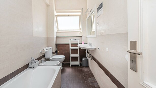 A bathroom with a bathtub, two sinks, a toilet, and a window. - HOUZE Spacious flat in Charming&Historical Lisbon (Lisboa)