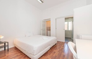A bedroom with a bed, bedside table, and a bathroom with a shower and toilet. - HOUZE Spacious 9 bedroom flat in Central Lisbon (Lisboa)