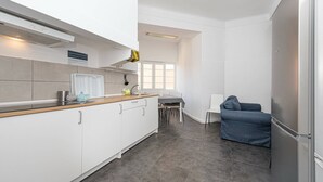 Eine moderne Küche mit weißen Schränken, einer Holzarbeitsplatte und einem Essbereich mit Tisch und Stühlen.