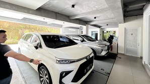 A parking garage with cars and a person pointing at a white car. - Stylish Double Suite with Balcony & Open Views (Bali)