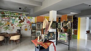 A room with a dining area, a wall with artwork, and shelves with books and decorative items. - Stylish Double Suite with Balcony & Open Views (Bali)