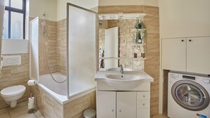 Apartamento | Banheiro | Banheira, secador de cabelo, toalhas de banho, sabonete
