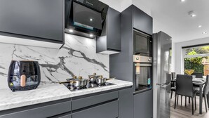 Een moderne keuken met een marmeren aanrechtblad, roestvrijstalen apparatuur en een eetgedeelte met uitzicht.