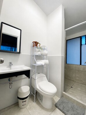 Ein modernes Badezimmer mit Toilette, Waschbecken und Dusche.