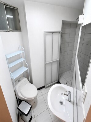 Ein modernes Badezimmer mit Toilette, Waschbecken und Dusche.