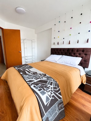 Ein Schlafzimmer mit einem Bett, einem Kleiderschrank, einer Pendelleuchte und einer Wanddekoration.