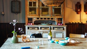A dining table with a vase, candles, and a bottle of wine. - Charming Garden Holiday Home for 6 (Weris)