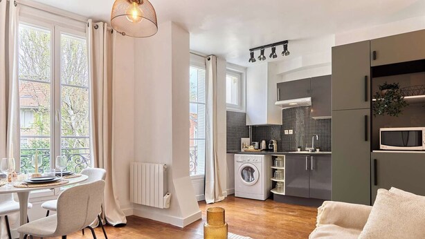 Eine moderne Küche mit Waschmaschine, ein Essbereich mit Tisch und Stühlen sowie ein Wohnbereich mit Sofa.
