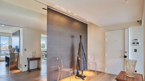 Ein modernes Interieur mit Holzboden, einer großen abstrakten Skulptur und einem minimalistischen Design.