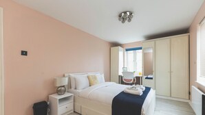 Una camera da letto con un letto, comodino, lampada e armadio.
