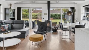 Una sala de estar moderna con chimenea, comedor y vistas al exterior.