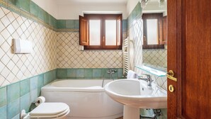 Une salle de bain avec une baignoire, des toilettes et un lavabo.