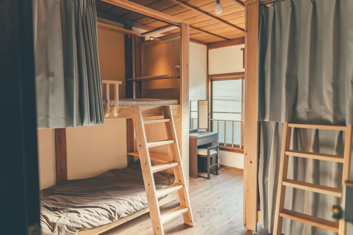 A small, compact room with a bunk bed, a desk, and a ladder.