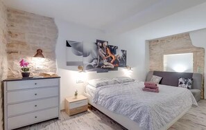 A bedroom with a bed, bedside tables, a lamp, a potted plant, and artwork on the wall. - Gorgeous home in Rovinjsko Selo with WiFi (Rovinjsko Selo)
