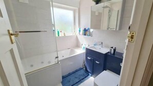 Ein Badezimmer mit Badewanne, Waschbecken, Toilette und Duschbereich.