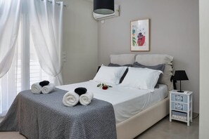 A neatly made bed with towels, a bedside lamp, and a small nightstand with drawers. - The Athenian Penthouse Residence - Central Escape (Athens)