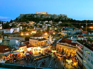 A historic cityscape with a prominent hilltop fortress, a bustling square with shops, and traditional architecture. - The Athenian Penthouse Residence - Central Escape (Athens)