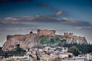 A historic cityscape with ancient ruins on a hill, modern buildings below, and a clear sky. - The Athenian Penthouse Residence - Central Escape (Athens)