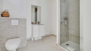 Un baño moderno con inodoro, lavamanos y ducha.