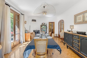 A dining area with a table set for six, a chandelier, and a view of the outdoors. - Guest Room – 40 m² Master Suite with Mountain View & Private Pool (Gap)