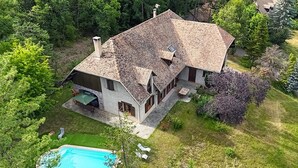 A two-story house with a sloped roof, a swimming pool, and a well-maintained garden. - Le Domaines Des Thermes – T2 with Shared Pool, Peaceful Setting, Mountain View (Gap)
