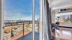 Un balcone con vista sulla città, un divano e un tavolo da pranzo.