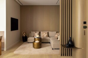 A modern living room with a sectional sofa, a round coffee table, and a minimalist decor style. - Luxury Flat -2br/6p- Madeleine/saint Honore (Paris)