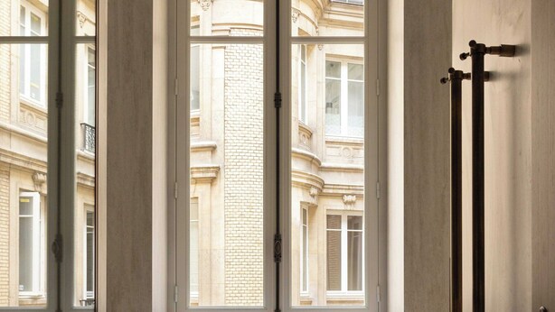 Une salle de bain moderne dotée d’une grande fenêtre, d’une étagère intégrée et d’un porte-serviettes.