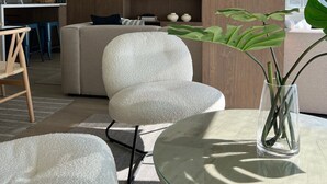Ein modernes Wohnzimmer mit einer Couch, einem Glastisch und einem an einer Holzwand montierten Fernseher.