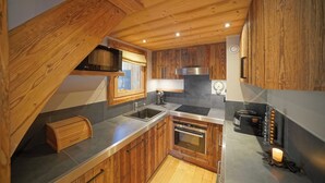 A kitchen with wooden cabinets, a stainless steel sink, a built-in oven, and a microwave.