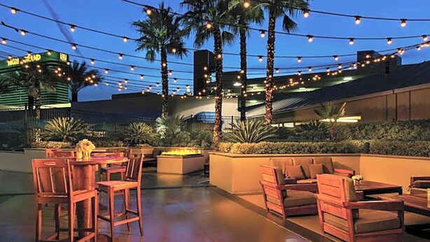 An outdoor patio area with wooden furniture and string lights. - Las Vegas Luxury suite with Jacuzzi, Pools, Free Parking, Walking to the strip (Las Vegas)