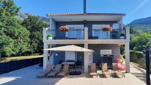 A two-story building with a balcony, a pool, and lounge chairs. - Awesome home in Solin (Solin)