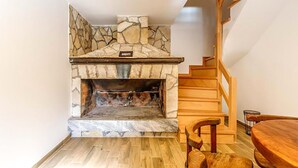 Ein Steinkamin mit einer danebenliegenden Holztreppe.