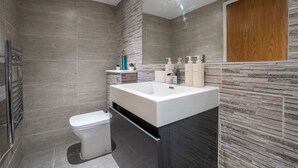 A modern bathroom with a large sink, a toilet, and a shower area. - Cosy Battersea Flat | Zone 2 London | Sleeps 5 | Free Parking! (London)