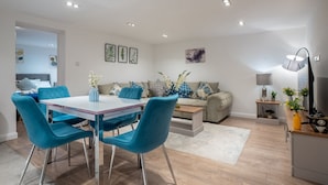 A modern living room with a dining area, a sofa set, and a coffee table. - Cosy Battersea Flat | Zone 2 London | Sleeps 5 | Free Parking! (London)