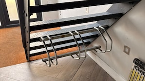 A metal staircase with a handrail, wooden flooring, and a radiator on the wall. - Cosy Battersea Flat | Zone 2 London | Sleeps 5 | Free Parking! (London)
