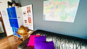 Ein Zimmer mit einer schwarzen Ledersofa, einem Globus und einer Karte an der Wand.