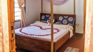 A four-poster bed with a canopy, a wooden ceiling, and a small window with curtains. - Afro Beach Safari (Mafia Island)