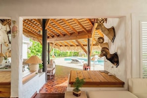 A room with a wooden ceiling, a mounted ram head, a pool, and a view of the outdoors. - Ocean View Villa, Pool, Bbq, Jacuzzi, Staff Incl (La Romana)