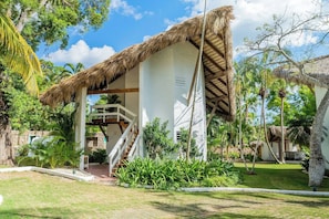 A resort with a thatched-roof structure, a staircase leading to an upper level, and lush tropical landscaping. - Ocean View Villa, Pool, Bbq, Jacuzzi, Staff Incl (La Romana)