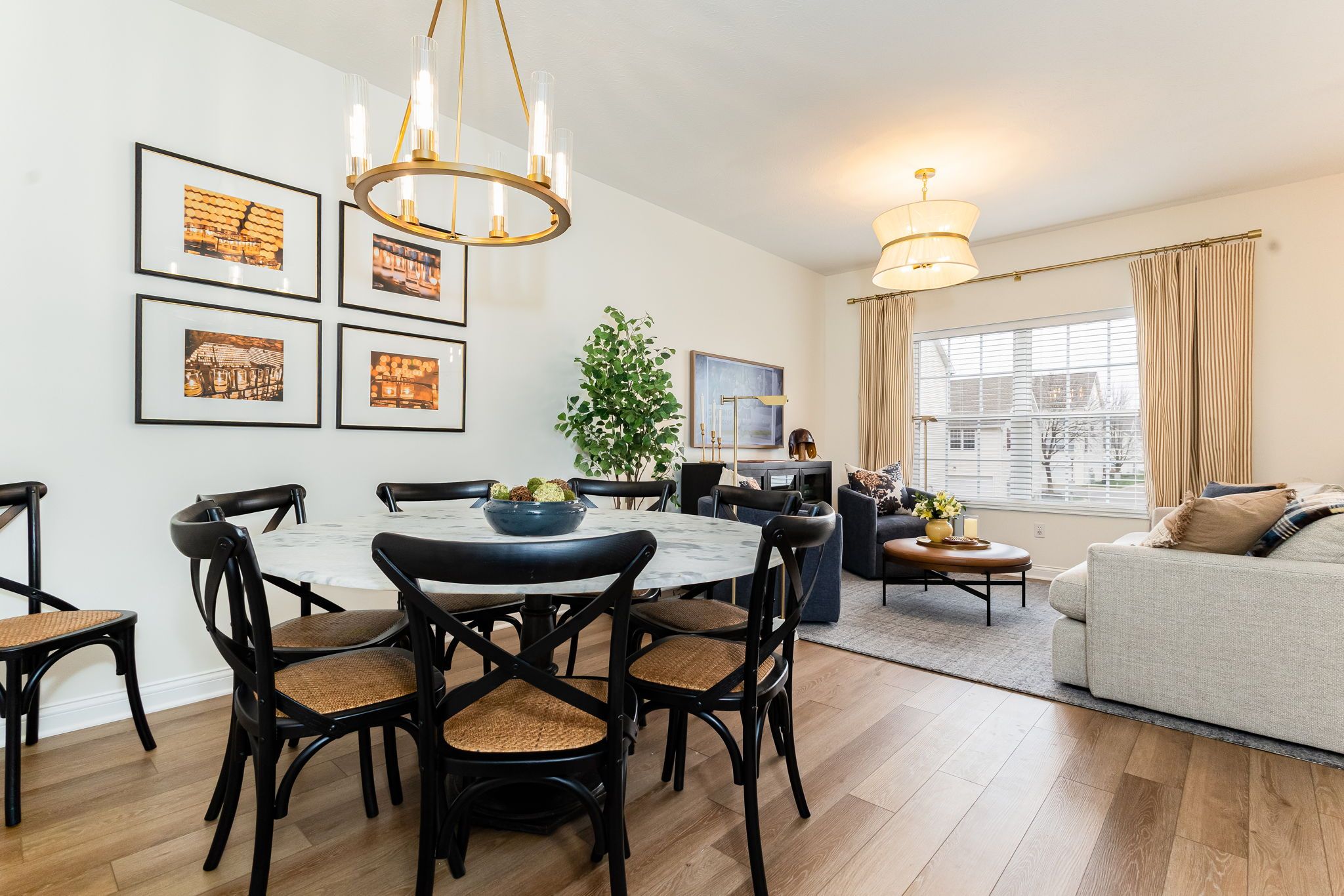 Un espace repas moderne avec une table ronde, des chaises noires et un lustre.