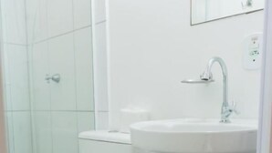 Un baño con inodoro, lavabo y cubo de basura.