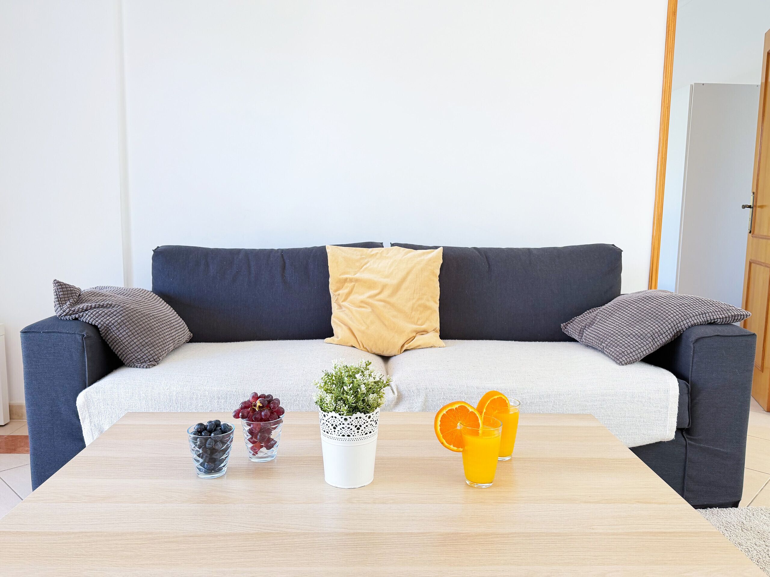 Una sala de estar con un sofá, una mesa de centro y una puerta.